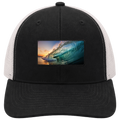 A black and white trucker hat featuring a rectangular patch on the front with a vibrant photograph of a curling ocean wave at sunset.